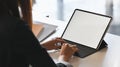 Behind shot of young businesswoman typing on tablet keyboard with white blank screen.