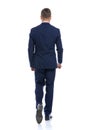 elegant young man in navy blue suit walking Royalty Free Stock Photo