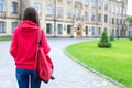 Behind view photo portrait of nervous scared stressed teen person looking at the door of her new place of studying wearing bright