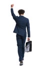 Behind view of young businessman holding fist up and celebrating Royalty Free Stock Photo