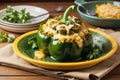 Stuffed green bell pepper with melted cheese on yellow plate