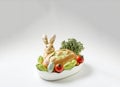 Easter bunny bread on a white ceramic dish with baby tomatoes and cabbage, Easter holiday food, generative AI Royalty Free Stock Photo