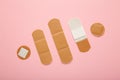 Beige adhesive bandages on pink background. Medical plasters Royalty Free Stock Photo