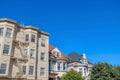 Beige apartment building with emergency stairs beside the victorian houses in San Francisco, CA Royalty Free Stock Photo