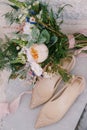 Beige ballet flats of the bride with a bouquet of flowers and a ribbon.