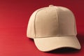 A beige baseball cap is positioned against a red background, with copy space Royalty Free Stock Photo