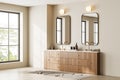 Beige bathroom interior with two sinks, dresser and window Royalty Free Stock Photo