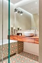 Beige bathroom with moroccan style floor tiles and wooden cupboard