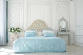 Bedroom interior. beige bed with blue linen in a white spacious airy room