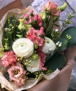 Beige bouquet. Pink roses, white Ranunnculus, pink eustoma and white Chamelauciumin a bouquet of fresh flowers on a light Royalty Free Stock Photo