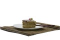 Beige cake on a white plate, on a rug, with chopsticks Royalty Free Stock Photo