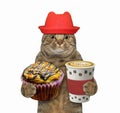 Cat holds orange cupcake and coffee 2