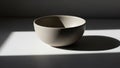 Beige ceramic bowl placed on a flat surface, casting a soft shadow Royalty Free Stock Photo