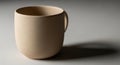Beige ceramic cup with a smooth texture placed on a light gray surface. The cup is rounded with a Royalty Free Stock Photo
