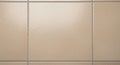 Beige ceramic tiles with a glossy finish, arranged in a grid pattern. The grout lines are Royalty Free Stock Photo