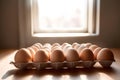 Beige chicken eggs same size in cardboard packaging on empty table Royalty Free Stock Photo