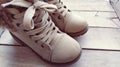 Beige children's boots with laces. Beautiful fashionable leather or suede shoes in a light shade on a wooden Royalty Free Stock Photo