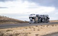 Beige classic big rig car hauler semi truck transporting cars on the semi trailer running on the road in Idaho Royalty Free Stock Photo