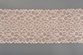 Color straight strip of lace fabric on a gray background. Elastic silk nylon braid border. use for clothes and linen decoration Royalty Free Stock Photo