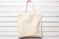 Beige cotton bag on a white wooden background. Top view