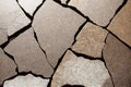 Beige cracked pieces of stone made cracked texture of wall. Long and short cracks on the damaged surface background of