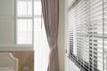 Beige curtain white color wooden blind with white ladder tape curtains.Sunlight through the windows in the city with garden.Select