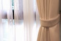 Beige curtain by the window in bed reception room. Royalty Free Stock Photo