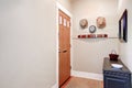 Beige entryway with cabinet, mirror ,hats hanging on the wall