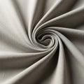 Beige fabric arranged in a spiral pattern, creating soft folds and texture. The material has a Royalty Free Stock Photo