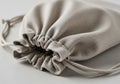 A beige, fabric drawstring bag is shown on a smooth, light-colored surface. The bag is loosely Royalty Free Stock Photo