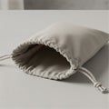 Beige fabric drawstring pouch lying on a gray surface. The bag features a simple desig Royalty Free Stock Photo