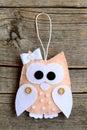 Beige felt owl ornament on an old wooden background. Pretty stuffed owl ornament. Closeup. Vertical photo Royalty Free Stock Photo