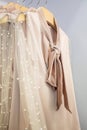 Beige female blouses on hanger in a fashion boutique.