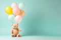 Beige fluffy bear kid toy with birthday balloon bunch in light pink yellow blue colours on minimal pastel background