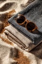 Beige and Gray Fabric with Brown Sunglasses on Sandy Beach Royalty Free Stock Photo