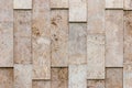 Beige-gray wall of natural textured stone blocks, irregularly arranged