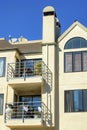 Beige house or home in apartment building detail shot with stucco exterior and visible windows and balconies with clear Royalty Free Stock Photo