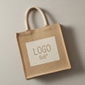 A beige jute tote bag features a rectangular white patch with \