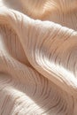 Beige knitted fabric displays a structured geometric texture enhanced by sharp directional lighting. The interplay of