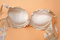 Beige lace bra with push up on orange background.