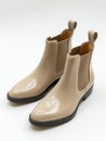 Beige leather chelsea boots on white background.