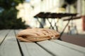 Beige leather purse on wooden bench outdoors, space for text. Lost and found