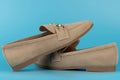 Beige loafers placed side by side on a blue background Royalty Free Stock Photo