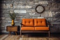 Beige lounge chair near orange loveseat sofa against wood and stone paneling wall. Mid-century style home interior design