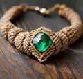 beige macrame necklace with a green crystal on wooden surface