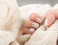 Beige Nails with dots nail desine holding knitted wool Royalty Free Stock Photo