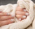 Beige Nails with dots nail desine holding knitted wool