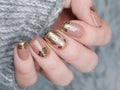 beige Nude manicure with gold lace pattern on a gray background