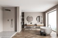 Beige panoramic bathroom with two on trend vanities and shower cabin