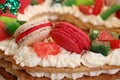 Beige and pink macaroon cookie and candies on a number cake